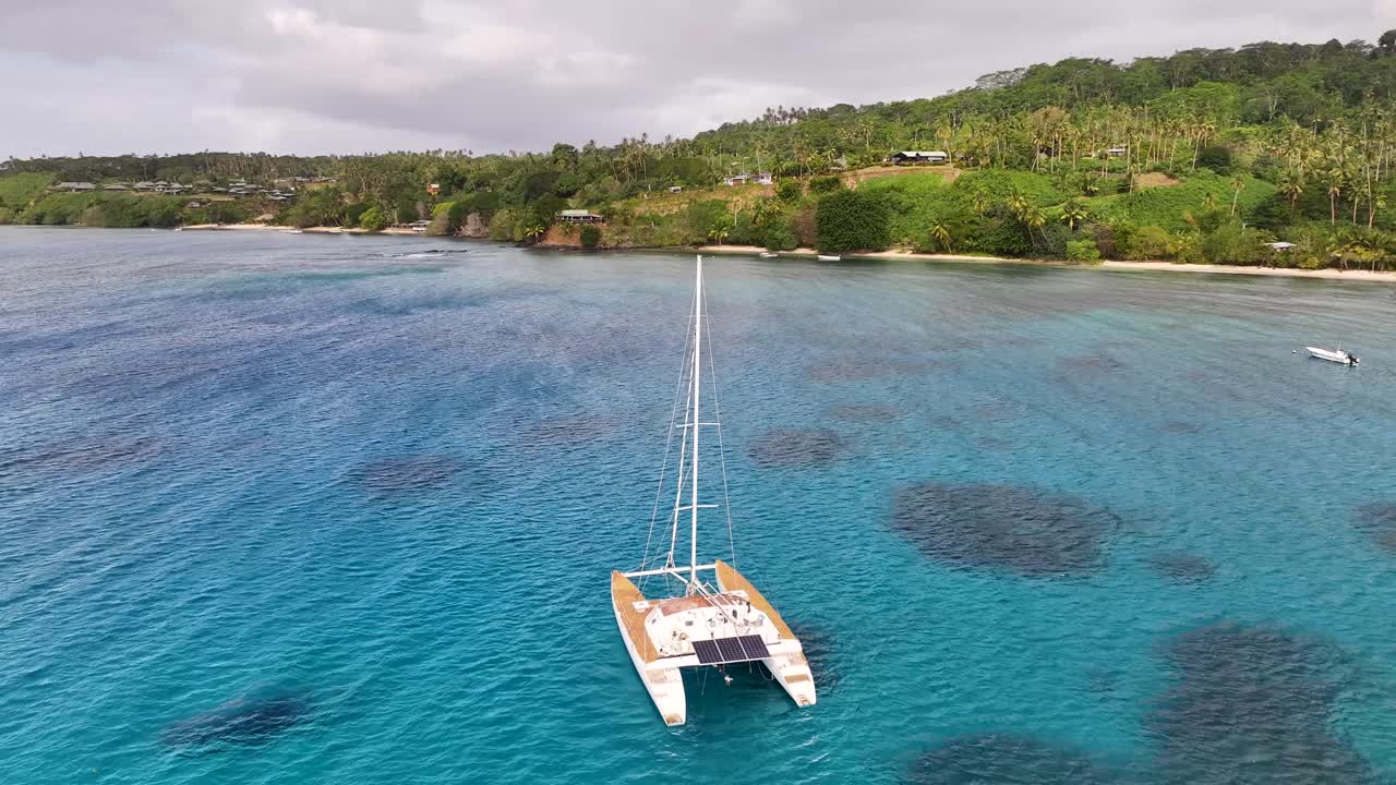 Catamaran at colourful and crystal clear water, Taveuni Island. Tropical coastal landscape, Fiji. Drone