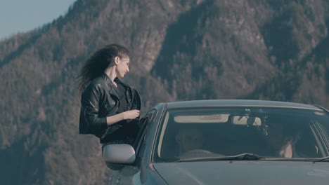 lady sits on automobile window and gets pleasure from car