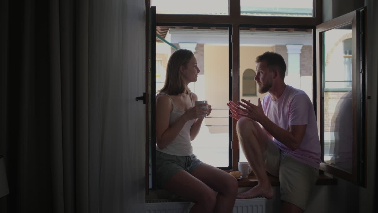 창문에서 대화하는 부부