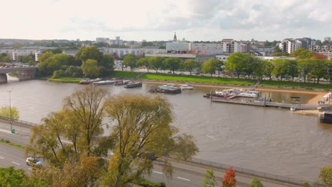 panoramic riverside view with boats, trees and cityscape in angers, france