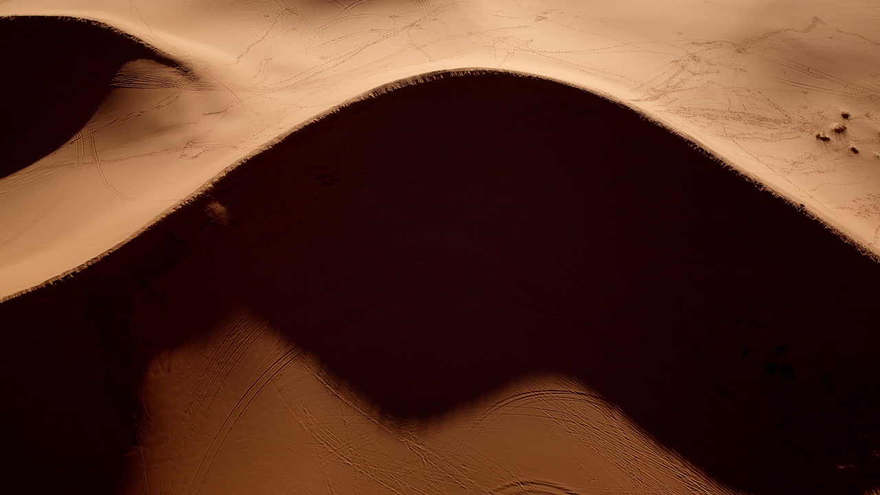 Surreal footage from above highlights the dreamy textures and soft pinks of Utah’s desert dunes.