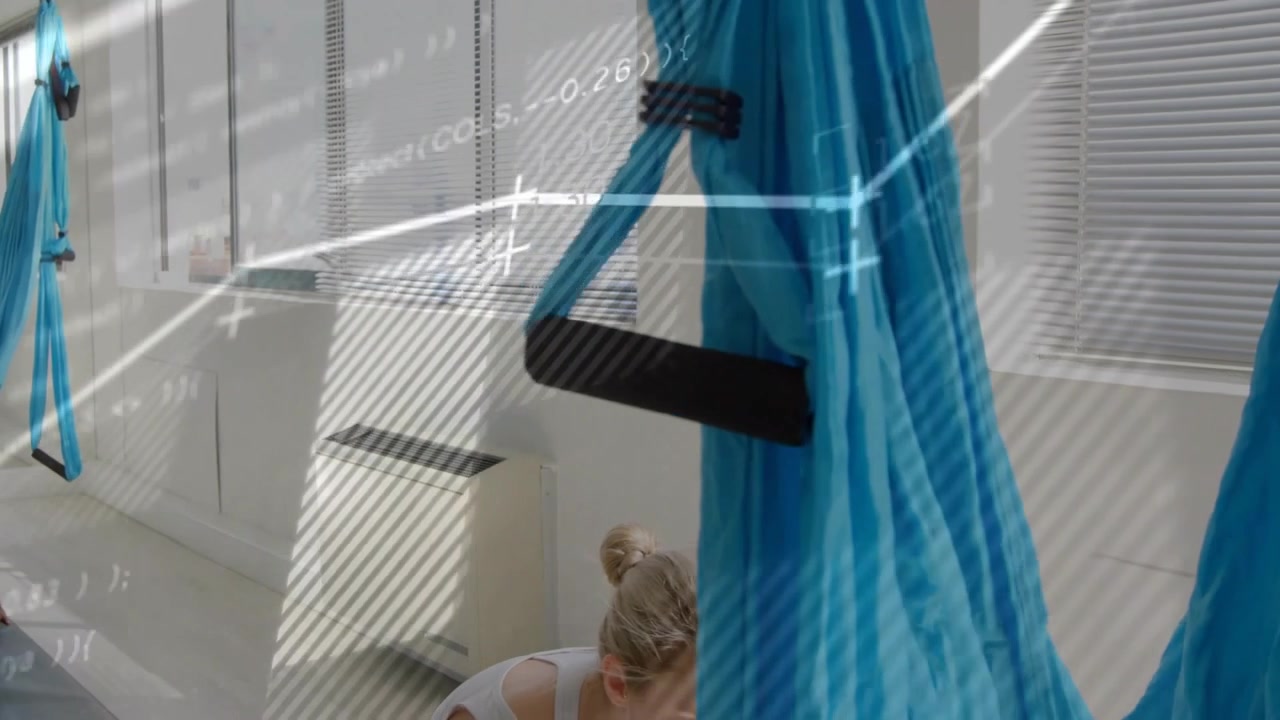 La telecamera si allontana, una donna si abbassa sul tappetino preparando una posa fitness, con sovrapposizioni che delineano la donna e le amache