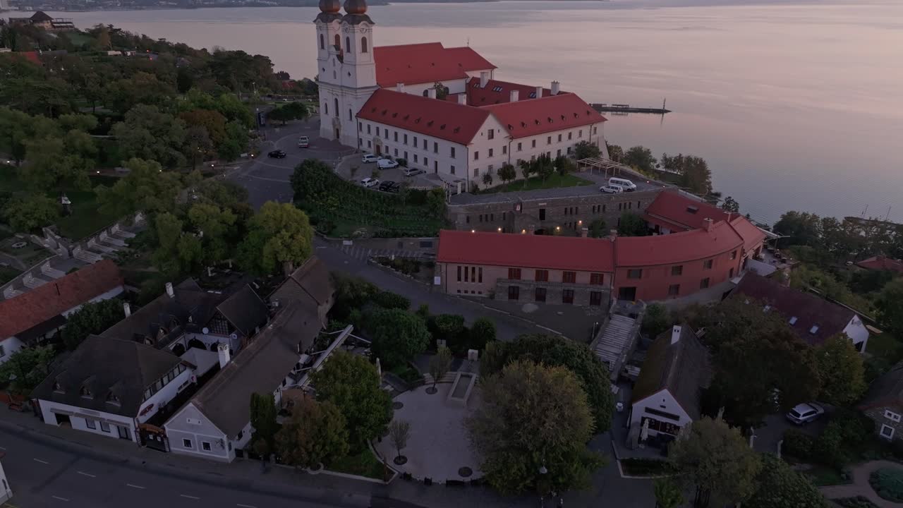 Ilmakuva kukkulalla sijaitsevasta luostarista auringonnousun heijastuksineen, Unkari.