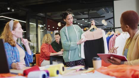 Happy-diverse-business-people-discussing-work-with-clothes-at-office