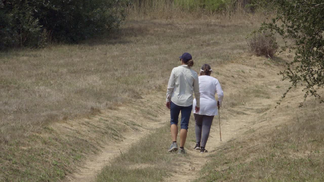 una maestra del instituto braille ayuda a una estudiante ciega a usar su bastón blanco en un ambiente al aire libre santa barbara california