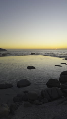 cinematic panning shot of popular camps bay tidal pool. cape town, south africa. sunset golden hour