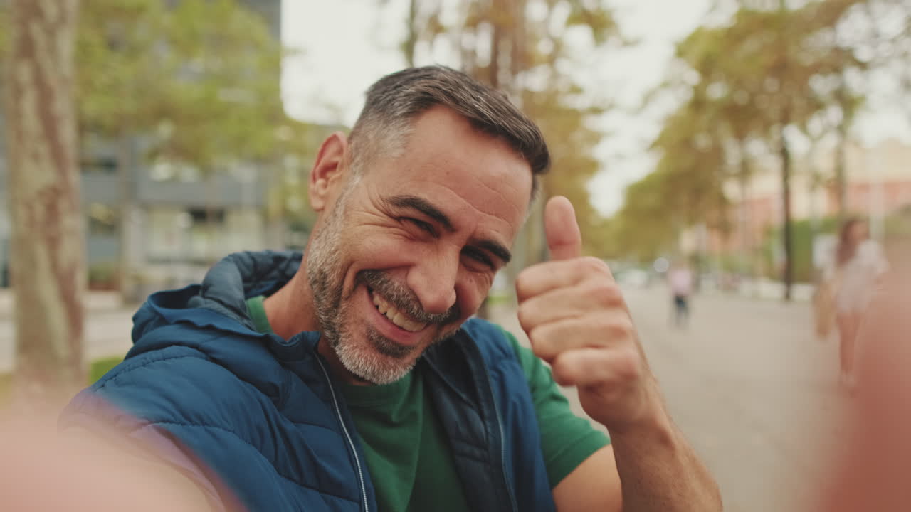 Man smiles outdoors in autumn city street selfie