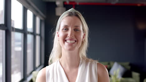portrait of smiling caucasian businesswoman in office with copy space