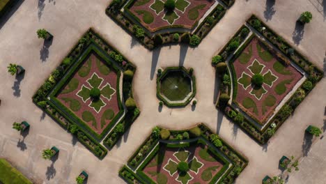 Aerial-circular-view-of-beautiful-French-garden-with-water-fountain-in-the-centre-at-the-backyard-of-Alden-Biesen-Castle-in-Belgium,-Germany