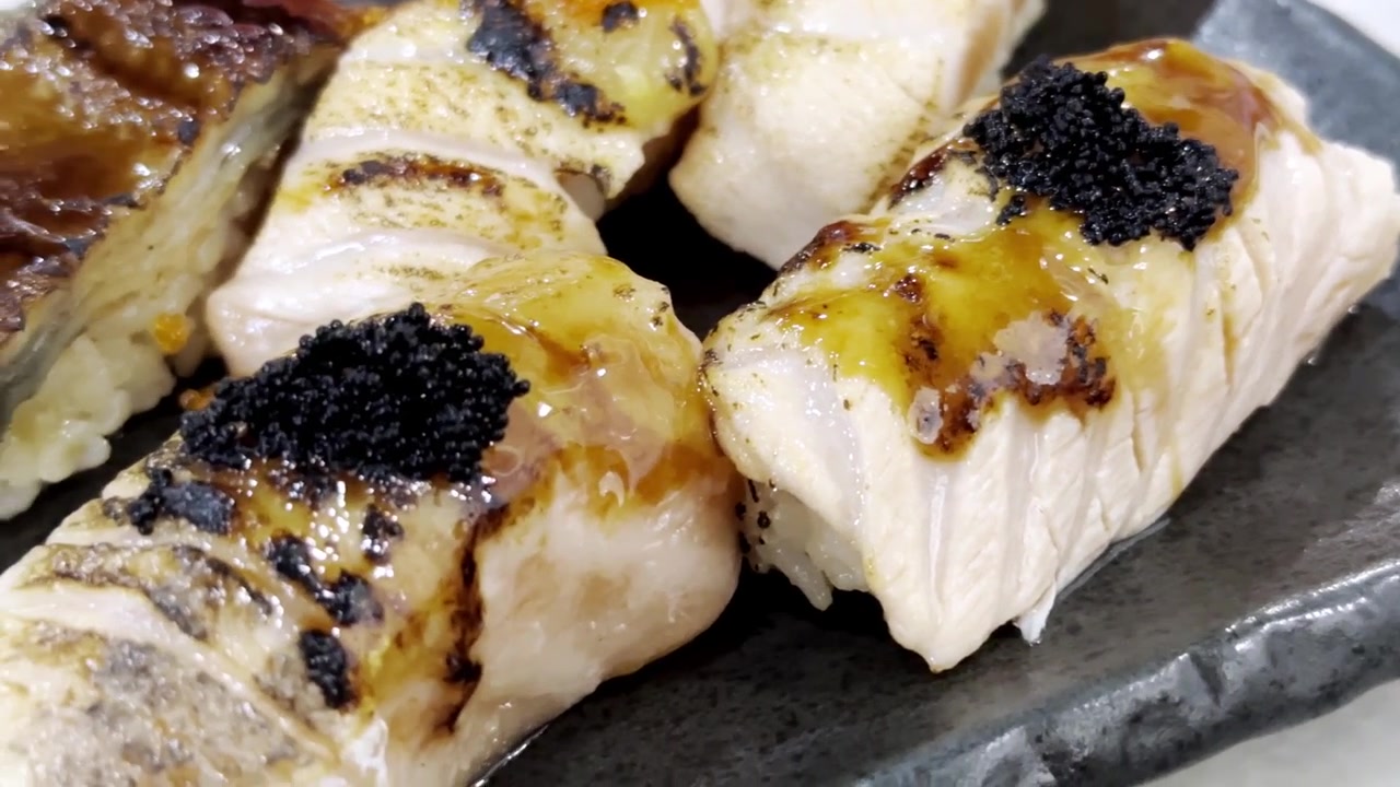 Närbild av premium engawa sushi med nigiri av flundrafena med delikat textur, elegant presenterad i en autentisk japansk restaurangmiljö.