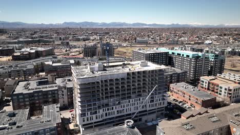 new building under construction with crane in big city, aerial dolly