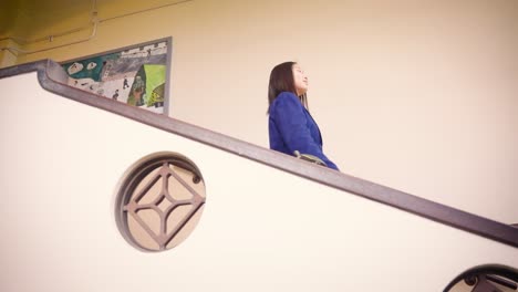 female japanese student descends stairs, low angle shot 4k