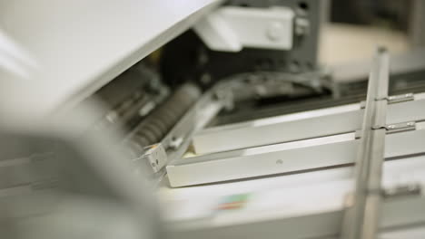 Close-up-of-a-printing-machine,-paper-traveling-on-the-line-in-left-direction
