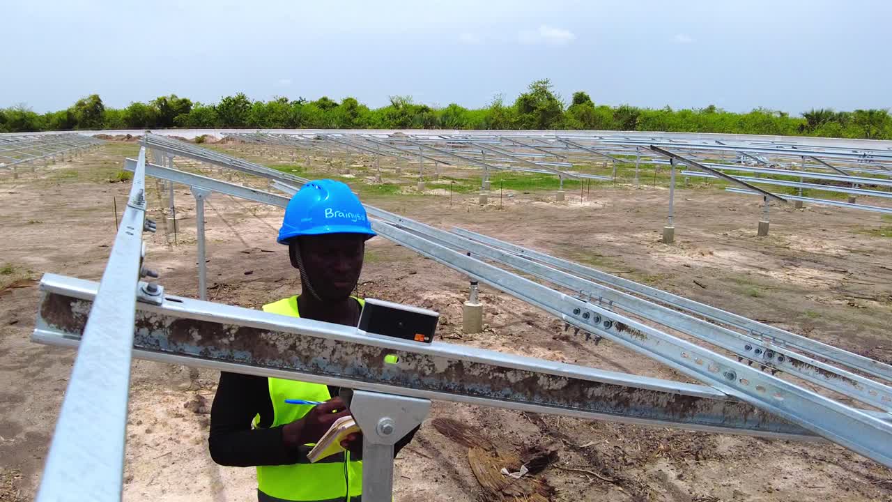 ingeniero africano con casco azul tomando paneles solares matriz estructura de haz ángulo de inclinación mediciones de primer plano