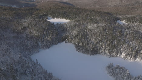 Frosted-Lake-Surrounded-With-Dense-Coniferous-Trees-In-Winterly-Forest-Near-Sutton,-Quebec-Canada