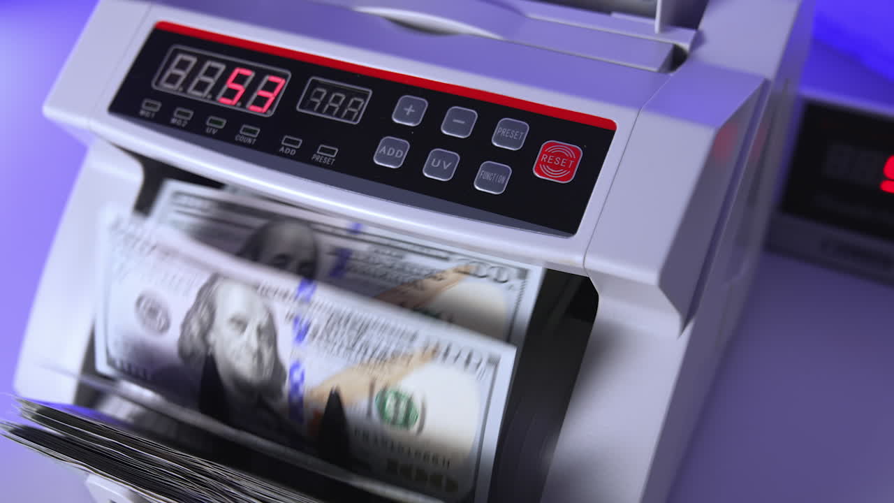 100 US dollar in money counting machine in action, close up