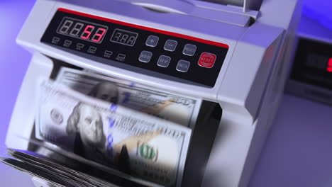 100 us dollar in money counting machine in action, close up