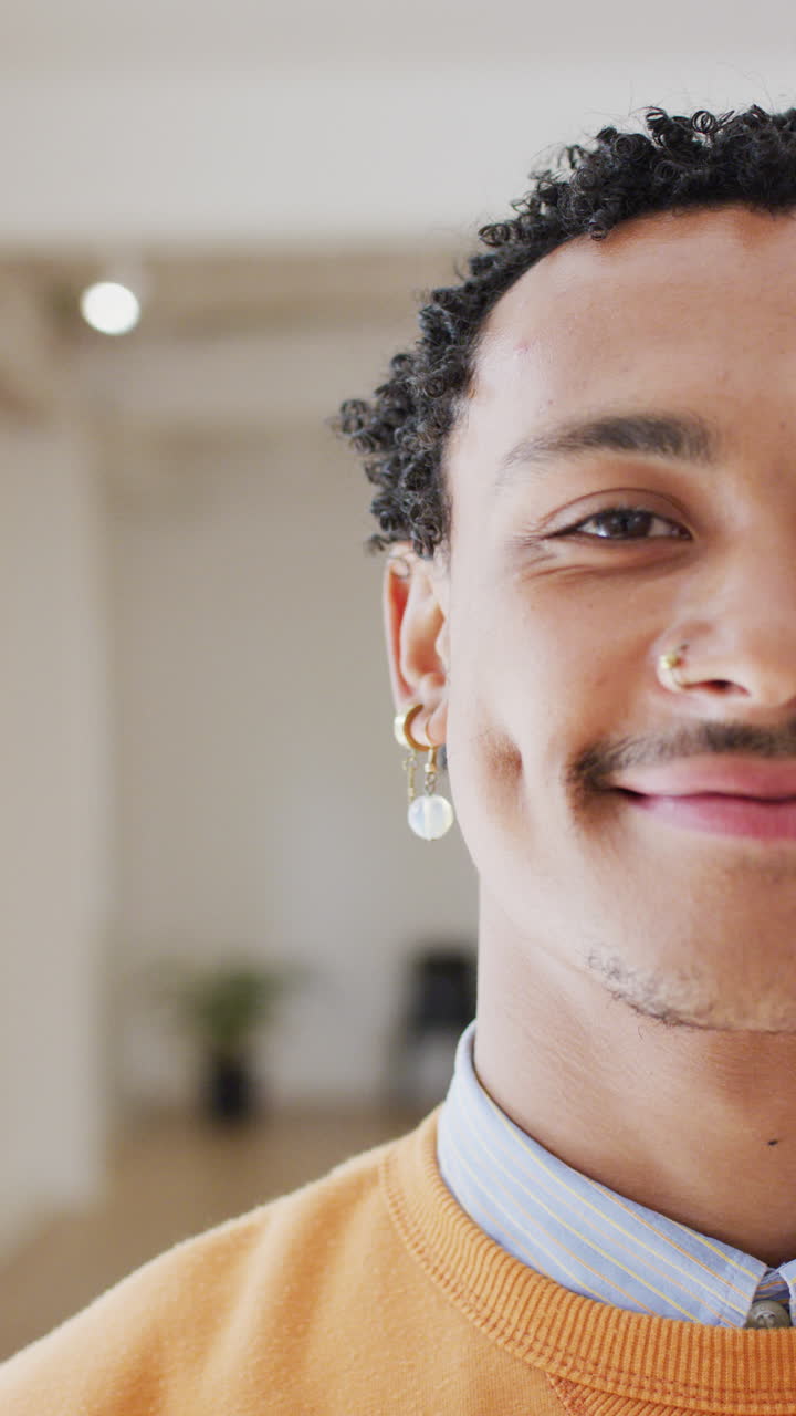 Vertical video of portrait of happy biracial man in dance studio