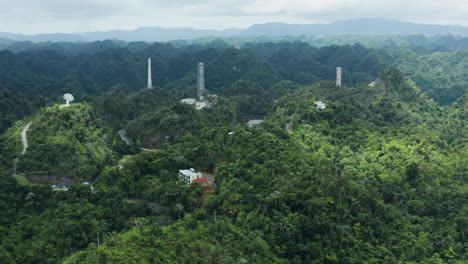 Slow-zoom-out-of-Arecibo-Observatory,-antenna-dishes-and-towers-in-Puerto-Rico-jungle