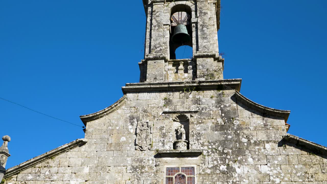 arriba establecer la inclinación de la entrada a la iglesia de san xoan de rio y el campanario contra el cielo azul