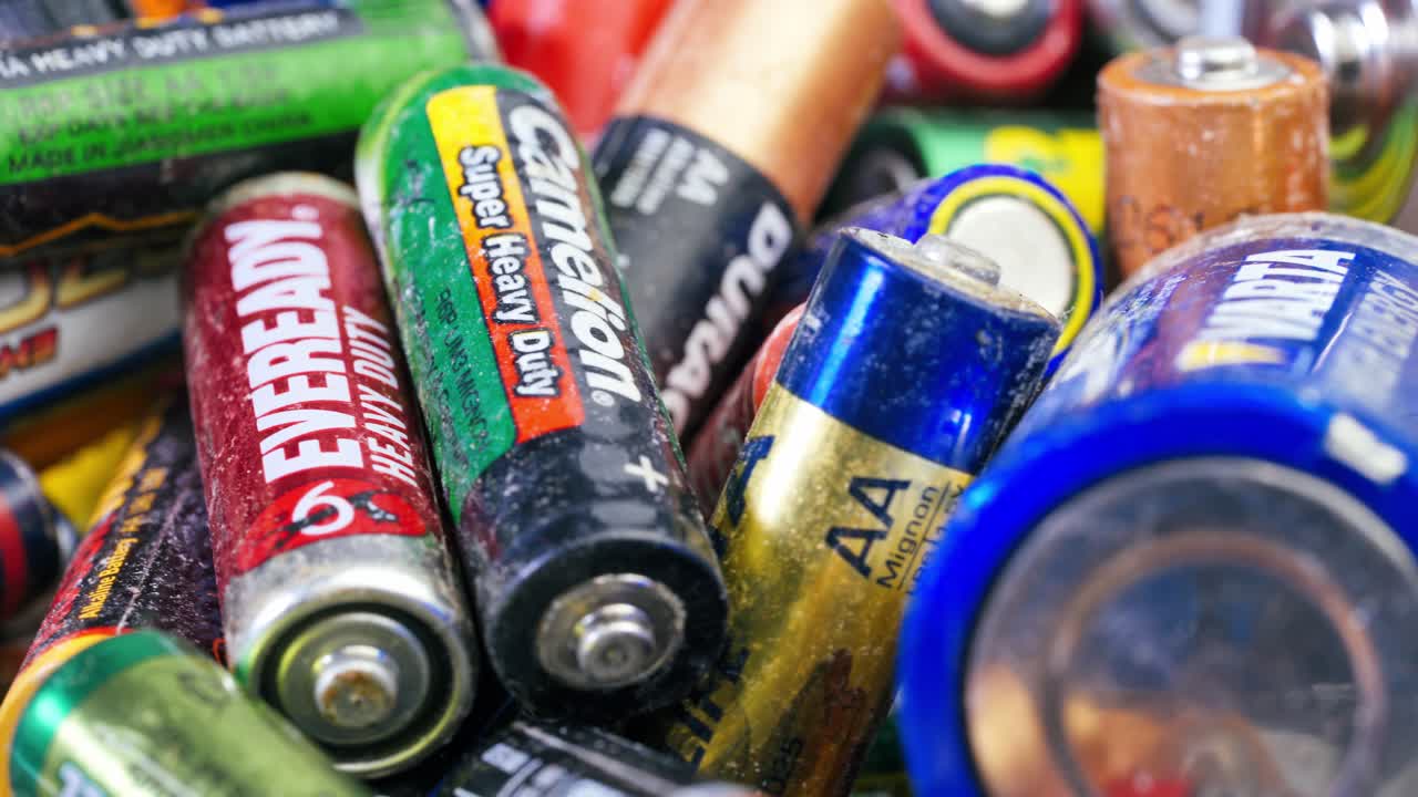 Used batteries from different manufacturers, waste, collection and recycling, high danger for the environment. Batteries background