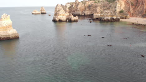 vista aérea de drones de la playa rocosa vacía y desierta y acantilados en lagos, algarve, portugal