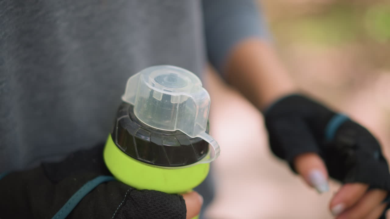 Moment Of Hand Gripping Water Bottle Cap, Detailed View Of Fingers Holding Bottle During Outdoor Break, Focused Shot Capturing Hand Firmly Gripping Water Bottle Cap During Nature Walk Pause