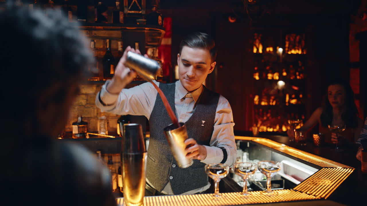 Primo piano di un barman esperto che versa una bevanda alcolica nello shaker in un ristorante