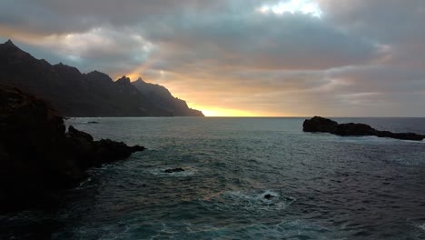 amanecer atardecer. olas del mar, océano agitado. imágenes aéreas de aviones no tripulados, olas chocando contra las rocas. hijo levantándose en el horizonte, detrás