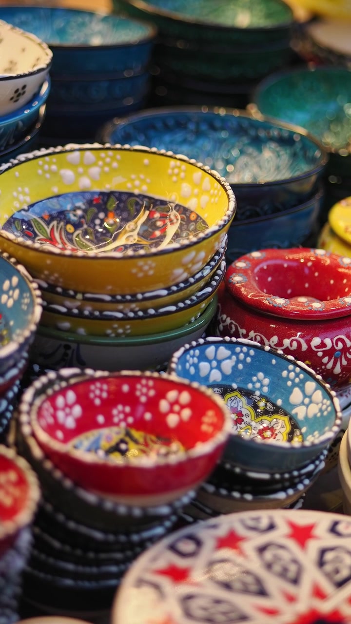 Ciotole di ceramica colorate e dipinte a mano esposte in un mercato