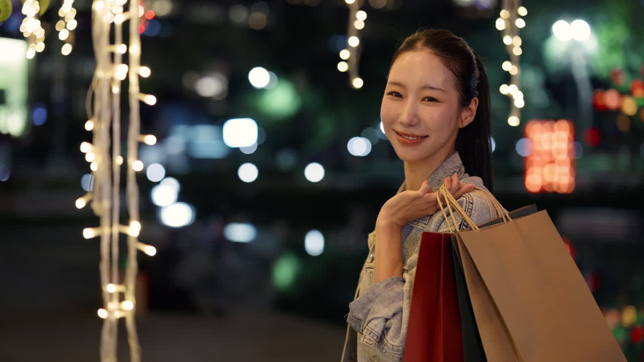 Woman with shopping bags at night