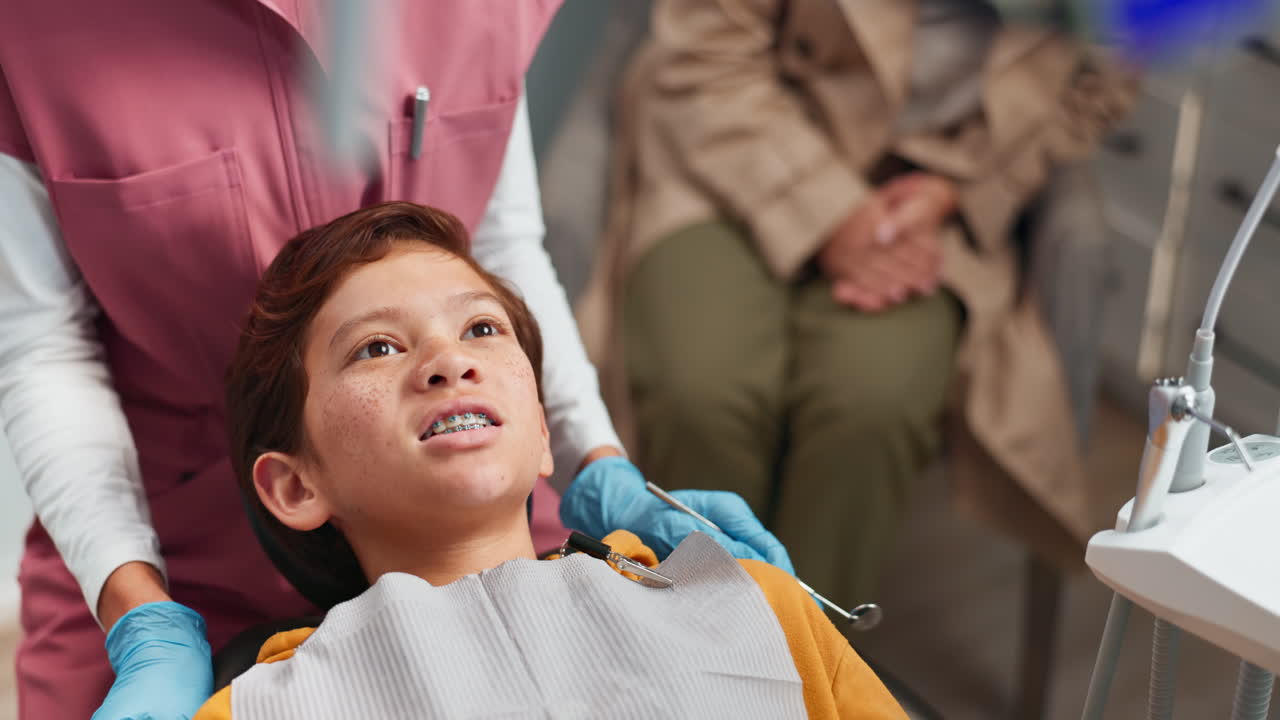 어린 소년 이 치과의사 에게 치아 를 검사 하고 있다