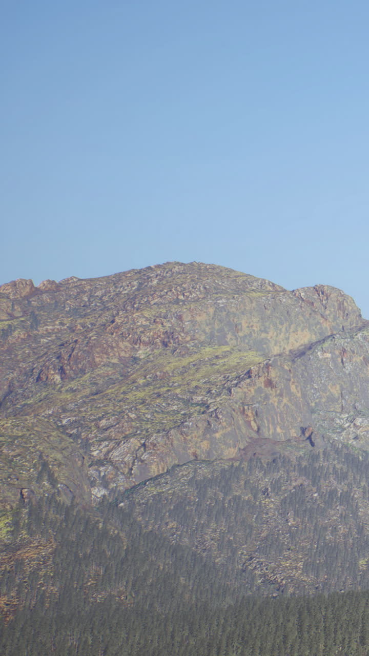 Montagne si ergono contro il cielo blu sotto un sole splendente in una località di alta quota.