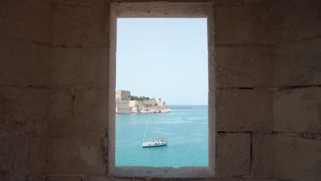 Vista-De-La-Ciudad-Medieval-Con-Costa-Marina-Y-Barco-Turístico-A-Través-Del-Marco-De-La-Ventana---Tiro-Estático