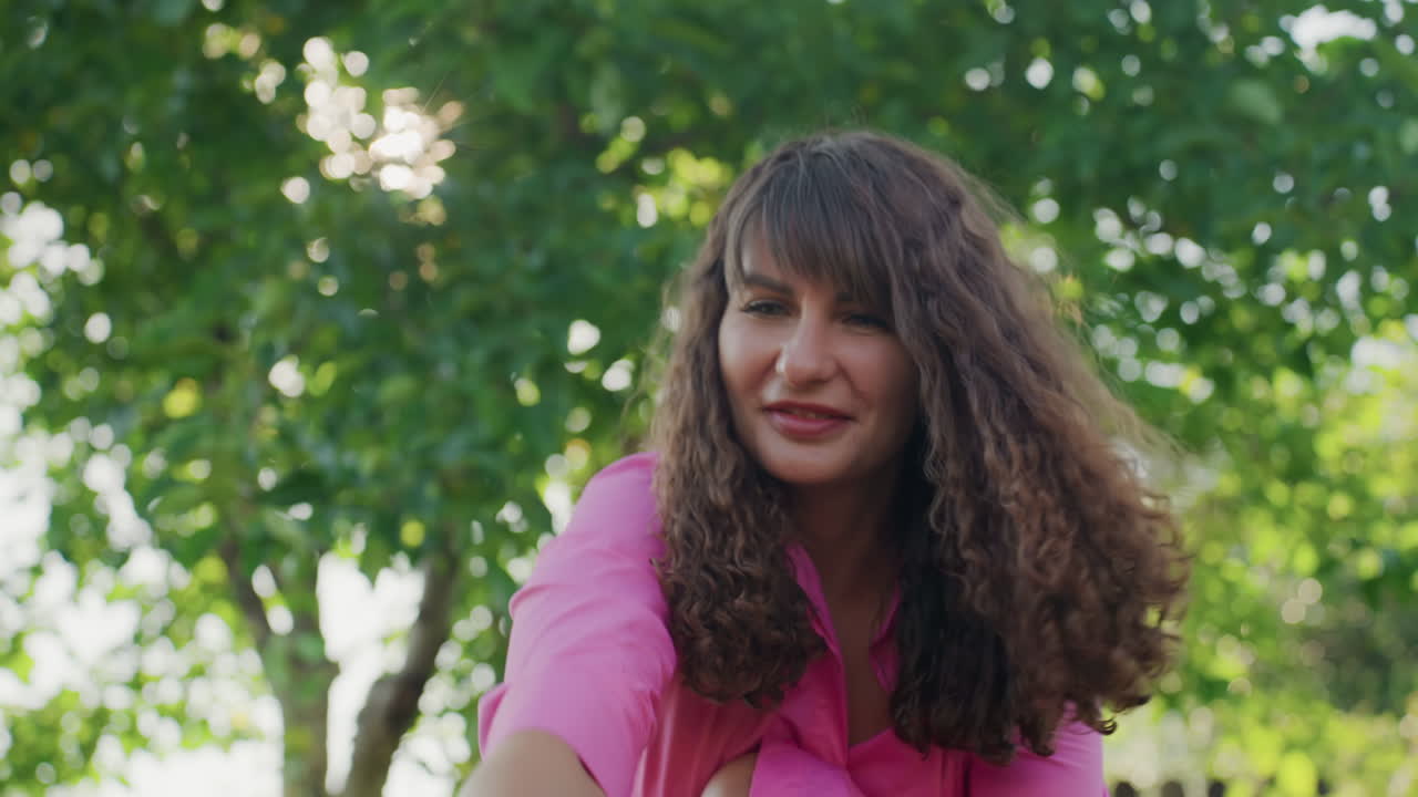 Caucasian Woman Leaning Forward Inspecting Dog In Shaded Garden, Thoughtful Concerned Expression, Soft Sunlight Filtering Through Trees, Attentive Owner Checking Pet Health And Behavior, Intimate