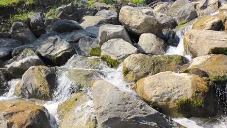 Crystal-clear-water-flowing-over-a-waterfall-with-many-moss-covered-rocks