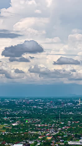 timelaspe of clouds passing over bali city surrounded by greenery, green fields, aerial view, vertical shot