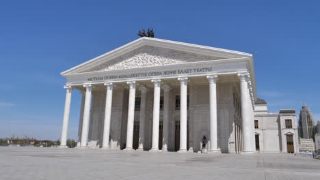 national opera theater of nursultan astana in kazakhstan with neoclassical architecture style. frontal view of the facade illuminated by sun.