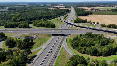 german autobahn motorway freeway junction on sunny summer day. aerial establishing wide shot. traffic scene on elevated interchange in european suburb. green trees in beautiful day