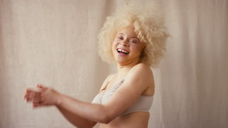 retrato de estudio de una mujer albina natural y segura en ropa interior que promueve la positividad corporal