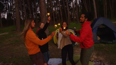 amigos divirtiéndose con chispas en el bosque 4k