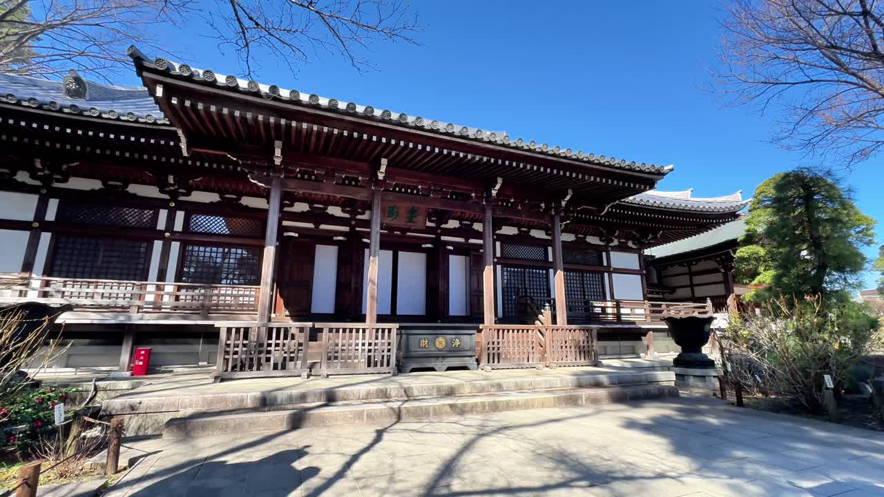 Traditionelt japansk tempel med fredfyldt have under klar blå himmel