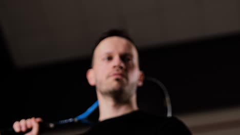 focused athlete tosses squash ball in low angle view, emphasizing control, calm
