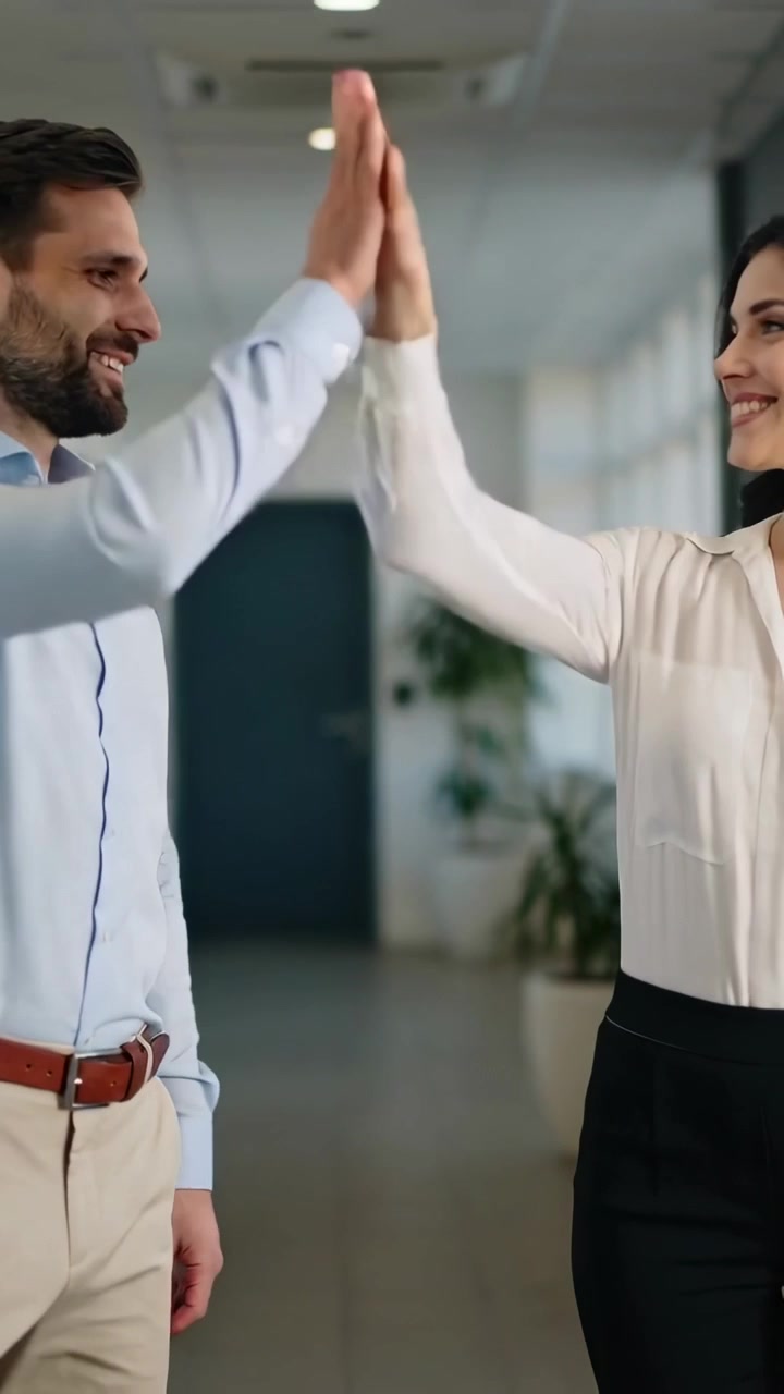 Video vertical: Colegas caminando con ropa de trabajo, mujer extendiendo la mano, iniciando un saludo de chocar los cinco en las ventanas.
