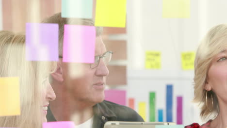 businessman writing on post it with his colleagues