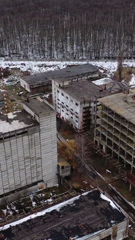 damaged industrial plant. old factory with abandoned buildings. desolate place after the military actions. view from above. vertical video