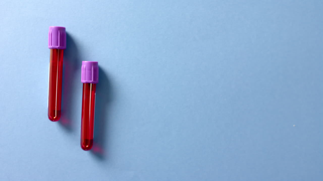 primer plano de muestras de sangre sobre fondo azul con espacio de copia, cámara lenta