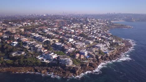 Birdeye-view-of-Sydney-eastern-suburb-coastal-houses-with-city-skyline,-Australia