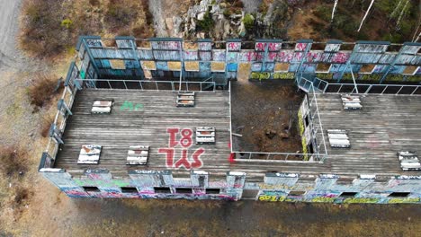 aerial top down showing old wooden paintball building with graffiti in wilderness