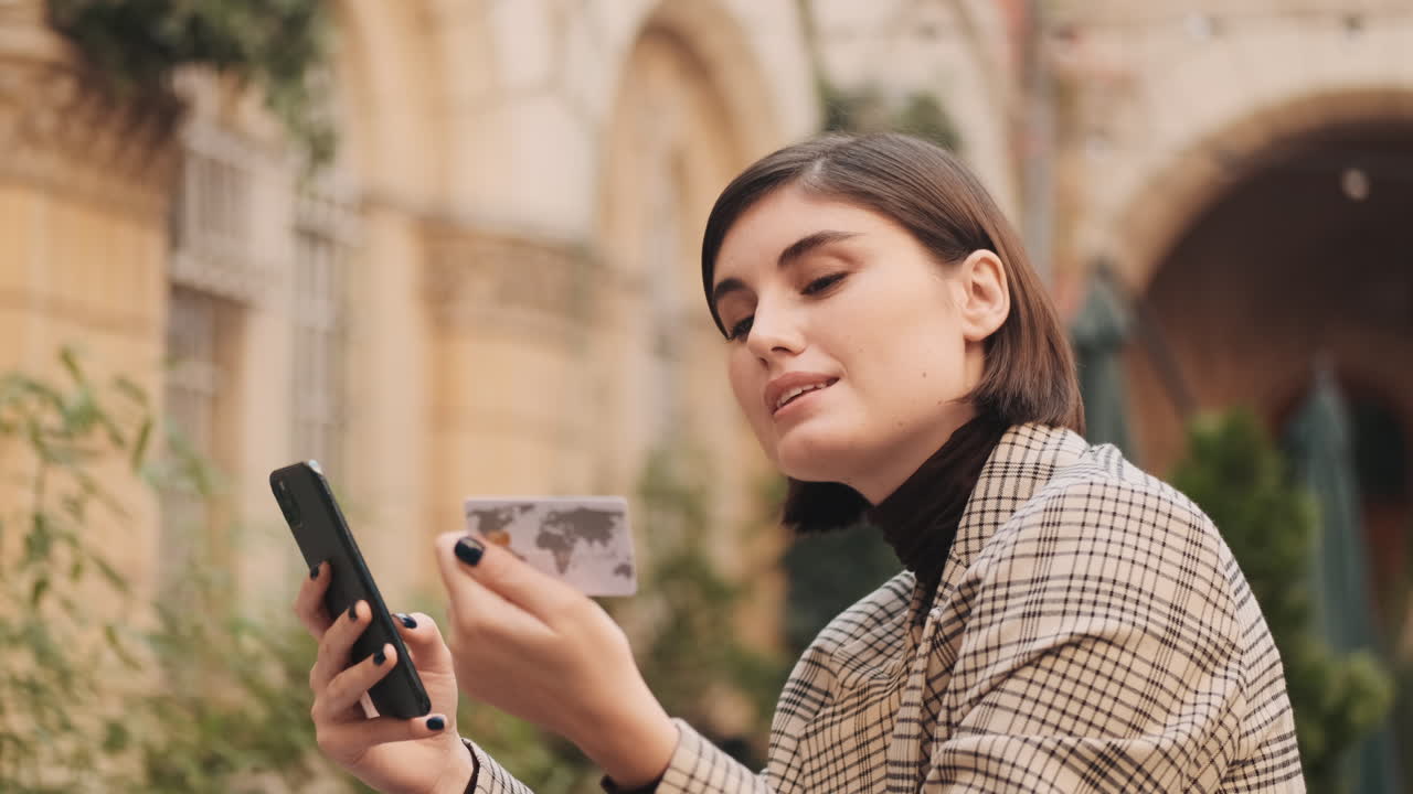 Young businesswoman making online payment on smartphone during coffee break.